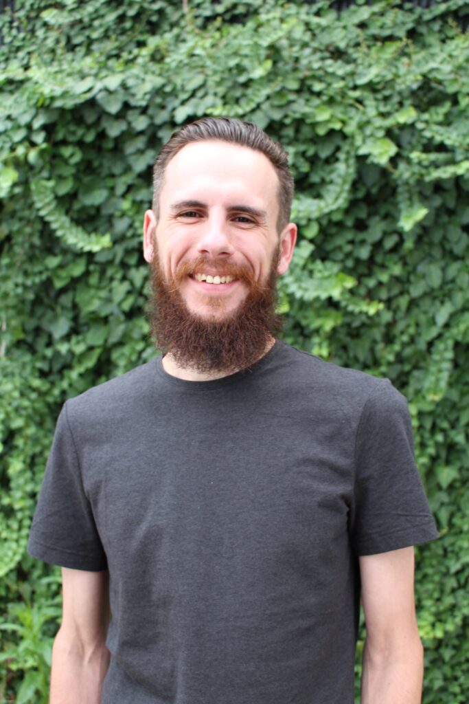 Justin Hero Image man standing in front of green background